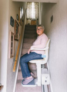 Older woman taking stair lift