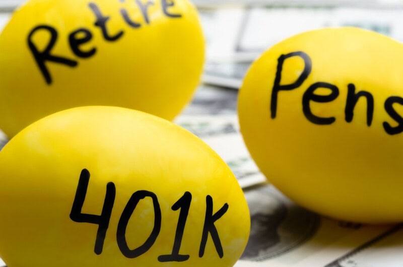 3 yellow eggs laying on top of cash Retire, 401K and Pension