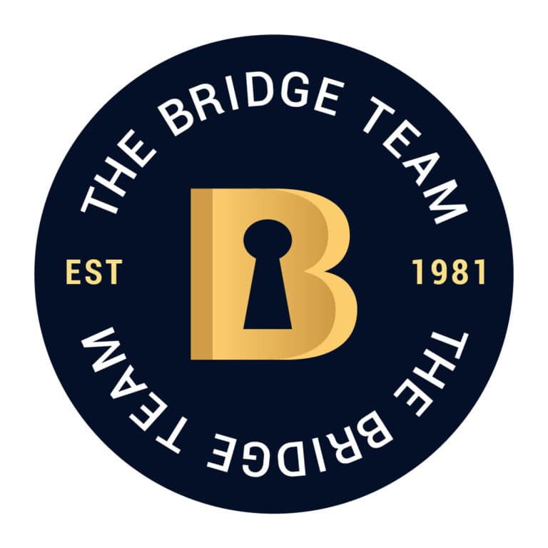 Dark circle with gold letter B (Key cut out to make the B) Est 1981 The Bridge Team around the circle