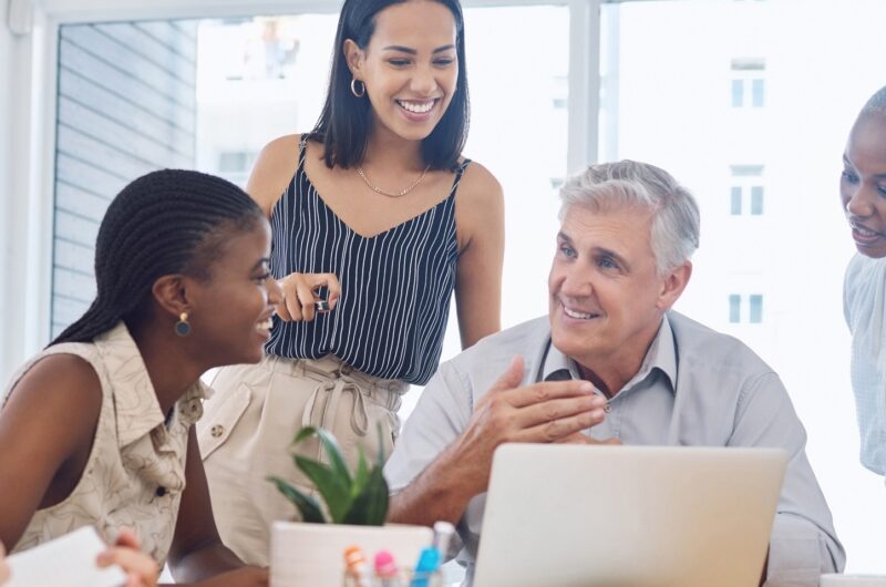 Older adult with younger adults in work environment