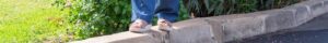 feet balancing on a curb