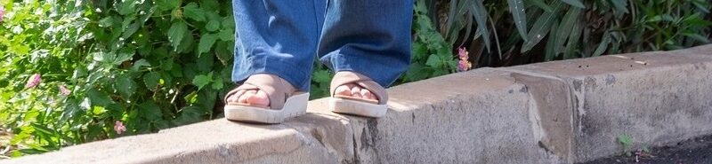 feet balancing on a curb